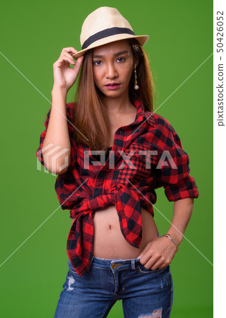 Young slim Asian woman against green background Young slim Asian woman against green background 50426052