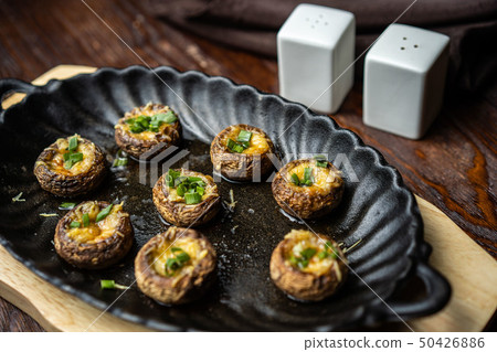 Traditional Italian Mushroom Caps stuffed with Feta as close-up in a rustic frying pan Traditional Italian Mushroom Caps stuffed with Feta as close-up in a rustic frying pan 50426886