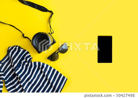 Flat lay traveler accessories on yellow background with blue dress, camera and sunglasses. Summer Flat lay traveler accessories on yellow background with blue dress, camera and sunglasses. Summer 50427498