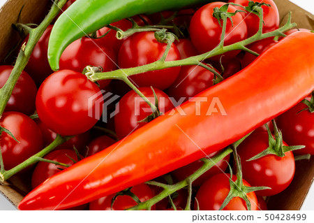 red pod pepper on a background red cherry tomato 50428499