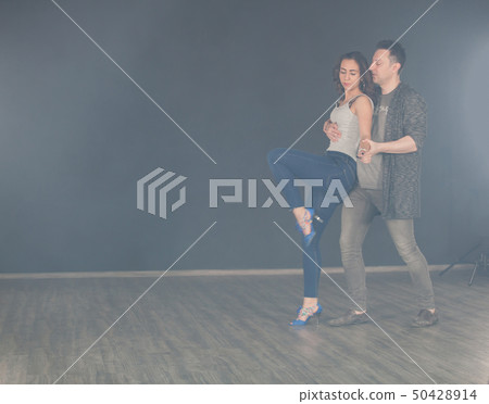 Beautiful kizomba dancer doing walking steps while her partner pickes her up Beautiful kizomba dancer doing walking steps while her partner pickes her up 50428914