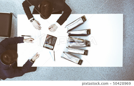 Two businessmen sitting at the table, view from above. Bookkeeper or financial inspector making 50428969