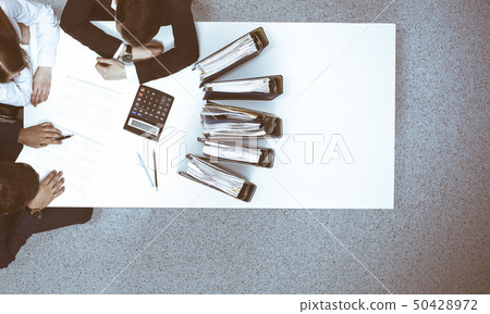 Business people at meeting, view from above. Bookkeeper or financial inspector making report Business people at meeting, view from above. Bookkeeper or financial inspector making report 50428972