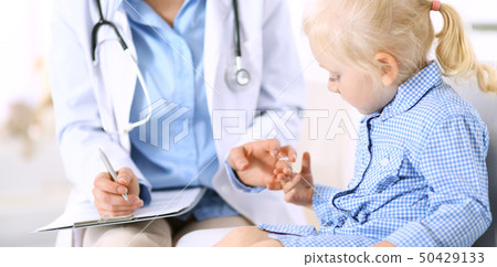 Doctor and a little blonde girl. Usual health exam. Medicine and healthcare concept Doctor and a little blonde girl. Usual health exam. Medicine and healthcare concept 50429133