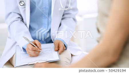 Doctor and patient talking. Physician at work in hospital while writing up medication history 50429194