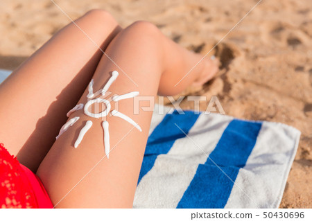 Sun cream is drawn in sun shape on tanned woman's Sun cream is drawn in sun shape on tanned woman's 50430696