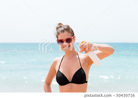 Young woman with sun protection spray for body at Young woman with sun protection spray for body at 50430716
