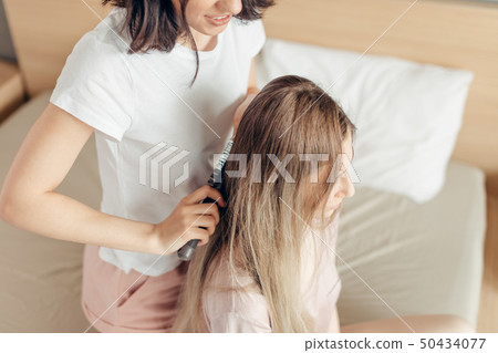 black-haired woman preparing her elder sister for a date 50434077