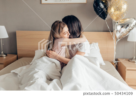 kind sister kissing her elder sister good night. 50434109