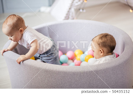 Little cute smile kids play with balls in ball pit in Play room. Birthday party Little cute smile kids play with balls in ball pit in Play room. Birthday party 50435152