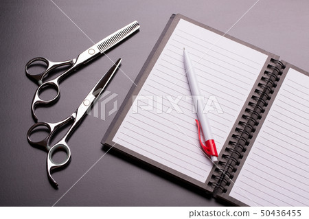 Barber scissors and open note book. Barber scissors and open note book. 50436455
