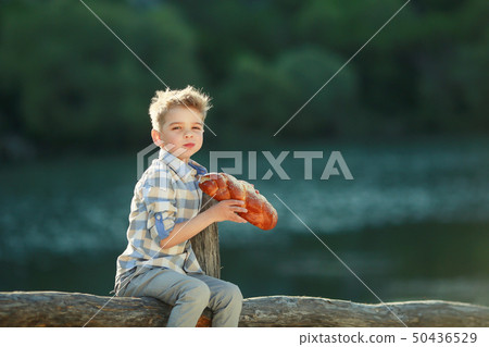 A Boys Stand near Wooden Fence in a willage 50436529