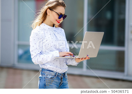 Closeup portrait of smiling blonde girl in eyeglasses holding notebooks Closeup portrait of smiling blonde girl in eyeglasses holding notebooks 50436571