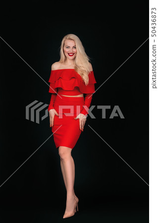 smiling young woman in red dress posing 50436873