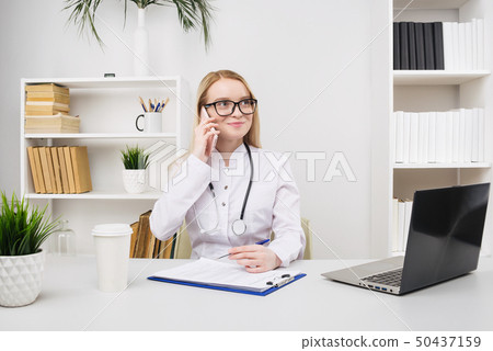 Portrait of a beautiful smiling woman doctor while 50437159