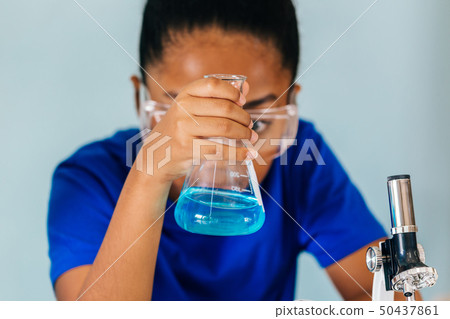 Young African American kid doing chemistry experiment Young African American kid doing chemistry experiment 50437861