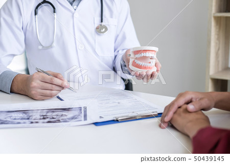 Male doctor or dentist writing report working with 50439145