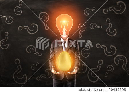 Man in suit with lightbulb instead head, levitating big shiny golden egg above palms, standing Man in suit with lightbulb instead head, levitating big shiny golden egg above palms, standing 50439398