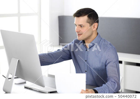 Cheerful smiling businessman working with computer in modern office. Headshot of male entrepreneur 50440072