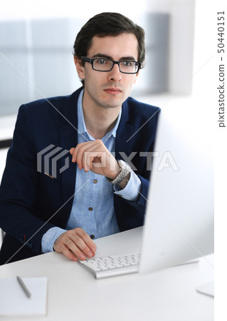 Businessman working with computer in modern office. Headshot of male entrepreneur or company manager Businessman working with computer in modern office. Headshot of male entrepreneur or company manager 50440151