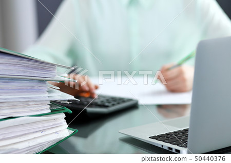 Bookkeeper or financial inspector making report, calculating or checking balance. Audit and tax Bookkeeper or financial inspector making report, calculating or checking balance. Audit and tax 50440376