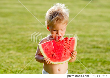 One year old baby boy eating watermelon in the 50441964