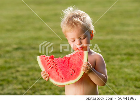 One year old baby boy eating watermelon in the 50441965