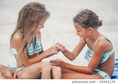 Little girls having fun at tropical beach playing together 50442239