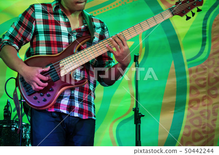 Bass guitar player on stage of ethnic open air concert Bass guitar player on stage of ethnic open air concert 50442244