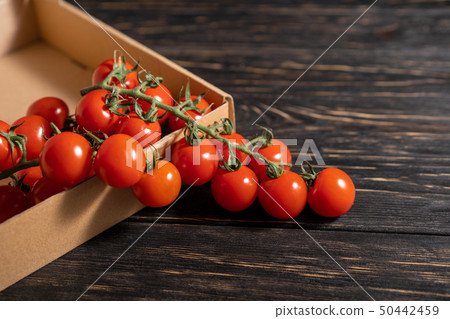 Cherry tomatoes in the cardboard box on the wooden 50442459