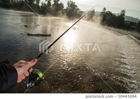 Man fishing in river with fly rod during summer morning. 50443894