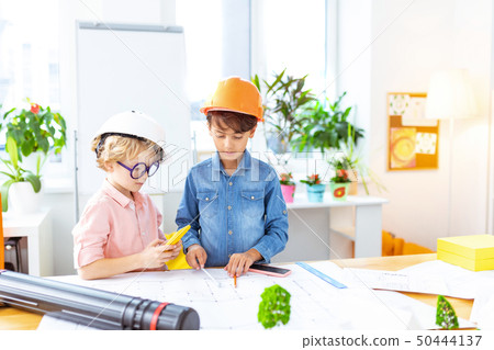 Boys wearing crash helmets feeling curious painting sketches Boys wearing crash helmets feeling curious painting sketches 50444137