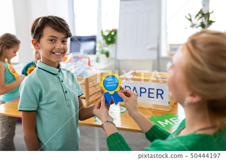 Boy feeling satisfied while getting reward at school 50444197