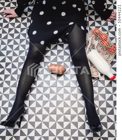 Woman sitting on a floor with bag and milk bottle 50444221