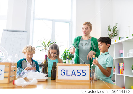 Teacher telling her pupils about glass recycling and waste sorting Teacher telling her pupils about glass recycling and waste sorting 50444330