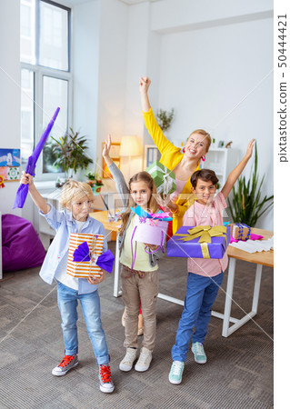 Schoolchildren standing near teacher with their boxes after art lesson Schoolchildren standing near teacher with their boxes after art lesson 50444421