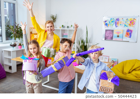 Pupils and teacher showing present boxes after decoration Pupils and teacher showing present boxes after decoration 50444423