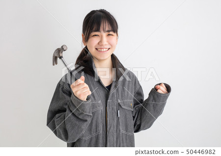 Industrial girl working on a white background studio shooting work clothes with a screwdriver Industrial girl working on a white background studio shooting work clothes with a screwdriver 50446982