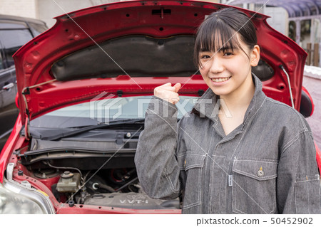 Guts posing smiling mechanic who is repairing a car with girl in working clothes 50452902