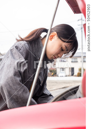 修理有一個女孩的女性技工一輛汽車工作服的 50452903