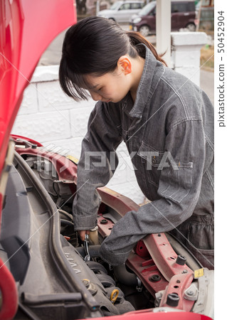 修理有一個女孩的女性技工一輛汽車工作服的 50452904