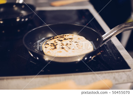Frying traditional imeruli on frying pan in the Frying traditional imeruli on frying pan in the 50455070