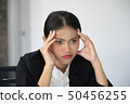 Portrait of frustrated young woman holding hand on 50456255