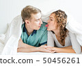 happy couple is lying in bed together. Enjoying 50456261