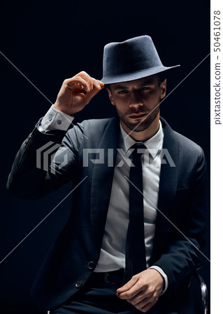 Young handsome man in black suit touch his hat on Young handsome man in black suit touch his hat on 50461078
