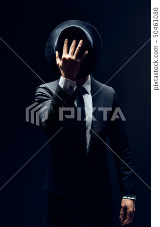 Man in suit hiding face behind his hat isolated on Man in suit hiding face behind his hat isolated on 50461080