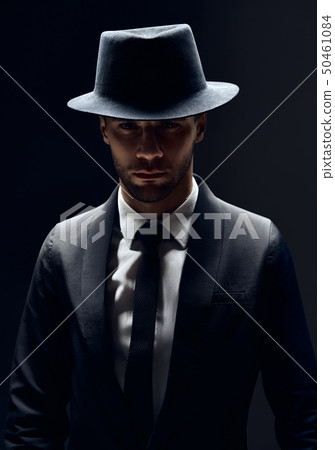 Handsome confident man in black suit and hat on 50461084