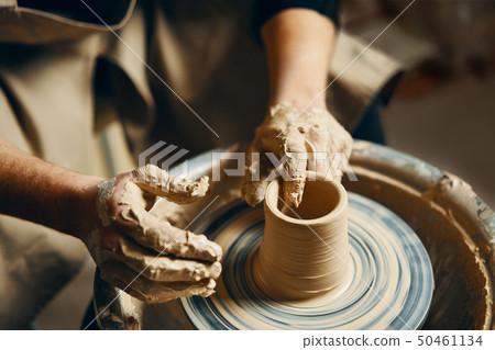 Potter modeling ceramic pot from clay on a 50461134