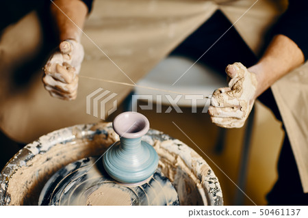 Man painting handmade pottery at ceramic workshop Man painting handmade pottery at ceramic workshop 50461137
