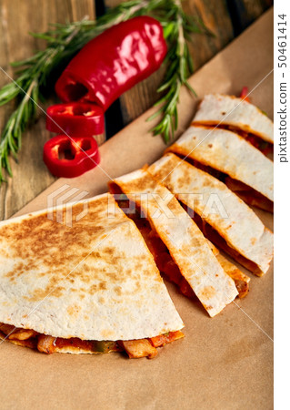 Mexican quesadilla with chicken, cheese and peppers on wooden table. 50461414